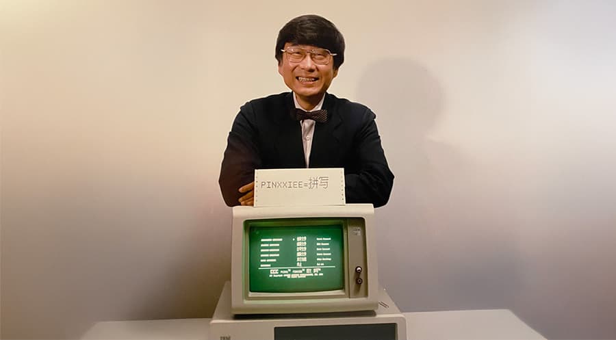 Dr. Hsin Chen “H.C.” Tien standing in front of a computer.