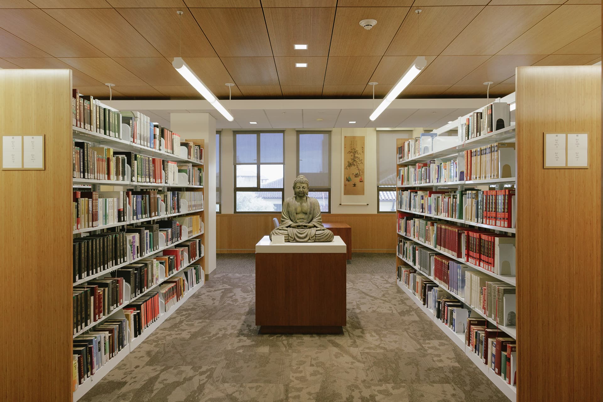 Display item and books on shelves in stacks by windows